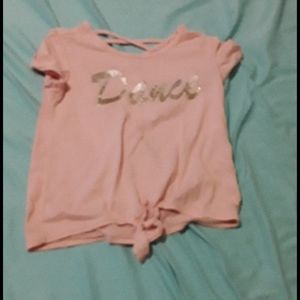 Pink shirt with the word dance that is in gold